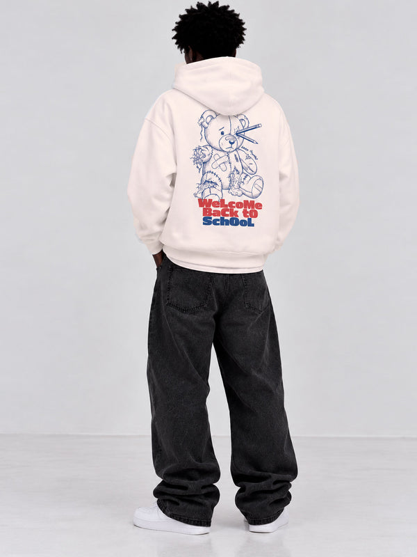 Sudadera blanca con diseño de oso y texto en rojo y azul en la espalda, pantalones oscuros.