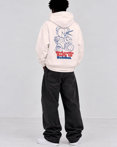 Sudadera blanca con diseño de oso y texto en rojo y azul en la espalda, pantalones oscuros.