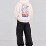 Sudadera blanca con diseño de oso y texto en rojo y azul en la espalda, pantalones oscuros.